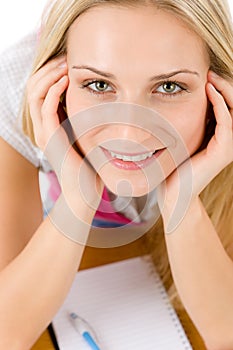 Happy student woman write homework at table