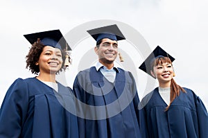 Happy students or bachelors in mortarboards