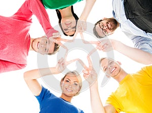 Happy students in colorful clothing standing together making a star with their fingers