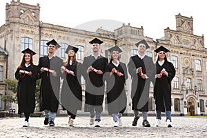 Happy students with diplomas. Graduation ceremony