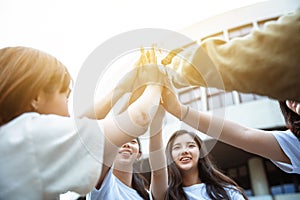 Happy students giving high five at school