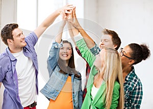 Happy students giving high five at school