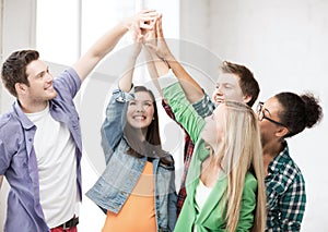 Happy students giving high five at school