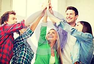 Happy students giving high five at school