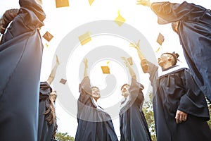 Happy  students in graduation gowns celebrating   in  university campus