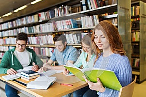 Happy students reading books in library