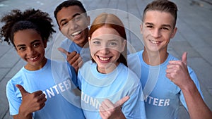 Happy students showing thumbs up smiling camera, college voluntary camp, care