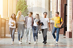 Happy students walking together in campus, having break