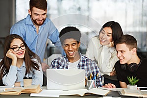 Happy students watching tutorial videos on laptop photo