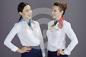 happy stylish air hostess women against grey background