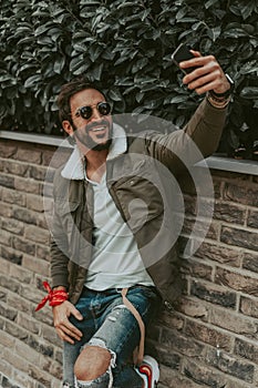 Happy, stylish, bearded man taking a selfie