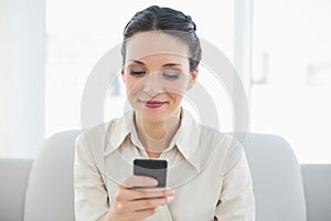 Happy stylish brunette businesswoman using her mobile phone