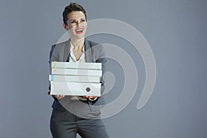 happy stylish business woman looking at copy space against grey