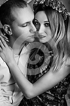 Happy stylish couple hugging and sitting  on background of luxury interior in studio, black white photo