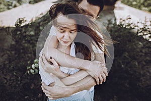 Happy stylish couple in love hugging on the beach in summer city