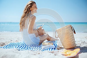 happy stylish female on beach using applications on tablet PC