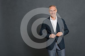 Happy stylish man adjusting button