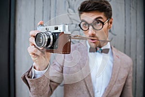 Happy stylish nerd with camera outdoors