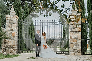 Happy stylish smiling couple walking in Tuscany, Italy on their wedding day. The bride and groom walk down the street by