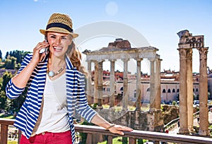 Happy stylish traveller woman in Rome, Italy using cell phone