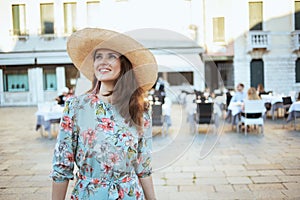 Happy stylish woman in floral dress enjoying promenade