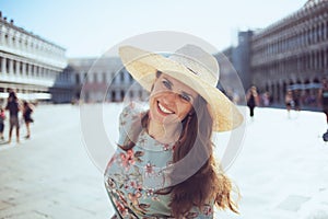 Happy stylish woman in floral dress enjoying promenade photo