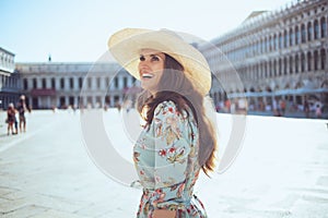 Happy stylish woman in floral dress exploring attractions photo