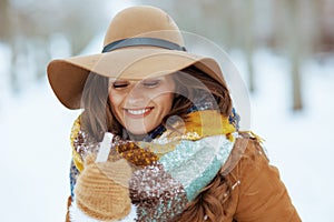 Happy stylish woman outdoors in city park in winter