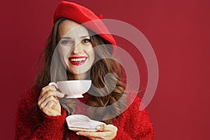 happy stylish woman in red sweater and beret with tea cup