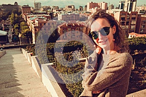 Happy stylish young woman in green sunglasses enjoy warm fall in Yerevan. Viewpoint cascade complex. City tour. Girl travel to