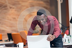 Happy successful African American businessman in a modern startup office indoors