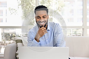Happy successful African freelancer man working from home