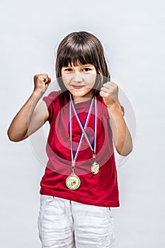 Happy successful boyish child with medals willing to win award photo