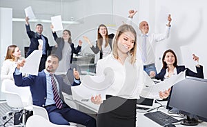 Happy successful business colleagues with smiling girl foreground in office