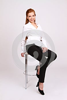 Happy successful business woman in chair on white background