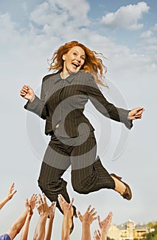 Happy successful business woman jumping