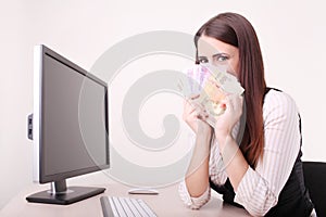 Happy successful Businesswoman in the office holding money with