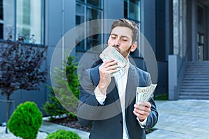 Happy successful Caucasian bearded businessman counts, waves, throws, show off, flaunt cash money background a modern office