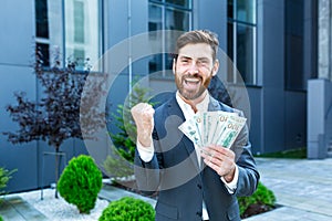 Happy successful Caucasian bearded businessman counts, waves, throws, show off, flaunt cash money background a modern office