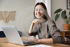 Happy successful entrepreneur woman working at laptop in home office