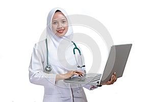 Happy successful female Asian Muslim nurse or doctor, smiling confidently with holding the laptop