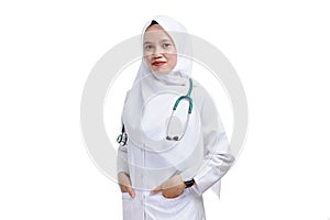 Happy successful female Asian Muslim nurse or doctor, smiling with hand in the bag