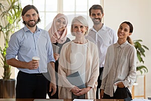 Happy successful international team of professionals posing for photo.