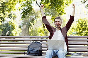 Happy successful man with arms raised in air