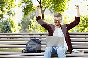 Happy successful man with arms raised in air