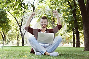 Happy successful man with arms raised in air