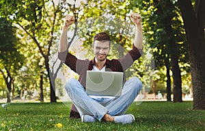 Happy successful man with arms raised in the air