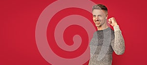 happy successful man in sweater on red background, success. Man face portrait, banner with copy space.