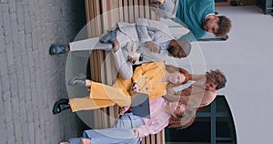 happy successful mixed-race young businesswomen and businessmen sitting on bench