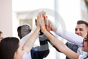 Happy successful multiracial business team giving a high fives gesture as they laugh and cheer their success